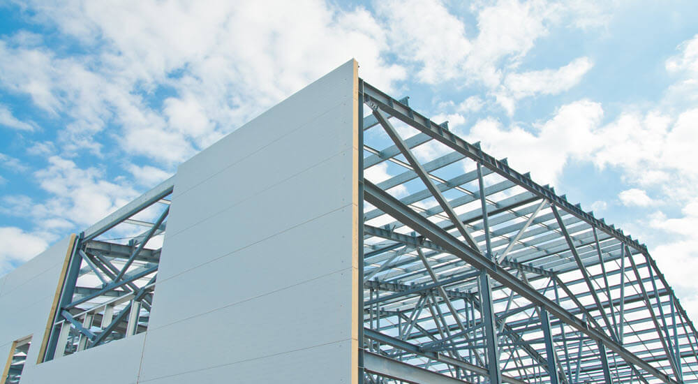 Metal frame of the building with a sandwich panel of insulation on the wall.